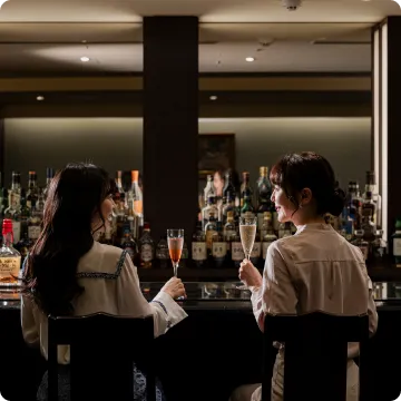 画像:バーで乾杯する女性